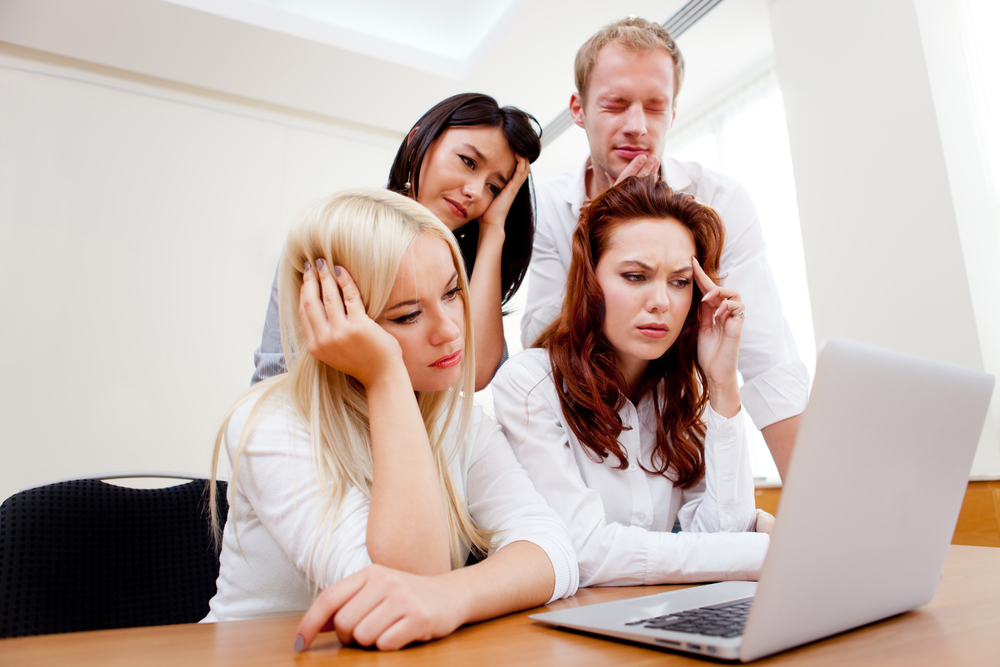 Worried business group going online on a laptop at the office